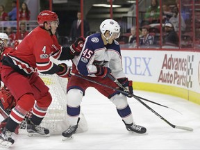 Carolina Hurricanes' Haydn Fleury (4) and Columbus Blue Jackets' Lukas Sedlak (45), of the Czech Republic, chase the puck during the first period of an NHL hockey game in Raleigh, N.C., Tuesday, Oct. 10, 2017. (AP Photo/Gerry Broome)