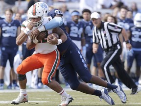 Miami quarterback Malik Rosier (12) is tackled by North Carolina's Jalen Dalton (97) during the first half of an NCAA college football game in Chapel Hill, N.C., Saturday, Oct. 28, 2017. (AP Photo/Gerry Broome)
