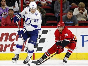 Carolina Hurricanes' Teuvo Teravainen (86) battles Tampa Bay Lightning's Mikhail Sergachev (98) for the puck during the first period of an NHL hockey game, Tuesday, Oct. 24, 2017, in Raleigh, N.C. (AP Photo/Karl B DeBlaker)