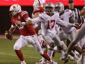 Ohio State linebacker Jerome Baker (17) and defensive end Jalyn Holmes (11) pursue Nebraska quarterback Tanner Lee (13) during the first half of an NCAA college football game in Lincoln, Neb., Saturday, Oct. 14, 2017. (AP Photo/Nati Harnik)