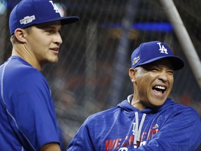 FILE - In this Oct. 13, 2016, file photo, Los Angeles Dodgers manager Dave Roberts, right, jokes with shortstop Corey Seager during batting practice before Game 5 of baseball's National League Division Series against the Washington Nationals at Nationals Park in Washington. The Dodgers earned a four-day break before the World Series with their quick resolution of the NLCS. (AP Photo/Pablo Martinez Monsivais, File)
