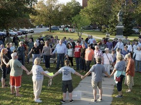 FILE - In this Sept. 12, 2017, file photo, a chorus of "We Shall Overcome" rises from a gathering against racism in Broad Street Park in Claremont, N.H. The demonstration was inspired by violence in August against an 8-year-old biracial boy that occurred while he played with a group of teenagers outside his home. The incident has prompted people in the town to reflect and assess how it handles the issue of race in this mostly white community. (James M. Patterson/The Valley News via AP, File)