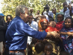 FILE- In this Wednesday, Oct. 25, 2017 file photo U.N. Secretary-General Antonio Guterres, left, shakes hands with people at Bangassou Cathedral Bangui, Central African Republic. Surrounded by hostile Christian militias, Muslim civilians in the volatile Central African Republic town of Bangassou have paid small fortunes to United Nations contractors to hide them in vehicles and take them to safety after U.N. peacekeepers repeatedly refused to do so, according to multiple people who made the journey. (AP Photo/Joel Kouam, File)
