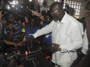 Former soccer star George Weah, Presidential candidate for the Coalition for Democratic Change cast his vote during a Presidential election in Monrovia, Liberia. Tuesday Oct. 10, 2017. Liberians gathered in masses under the bright sun Tuesday to vote in an election that for the first time in more than 70 years will see one democratically elected government hand power to another.  As Africa's first female president prepares to step aside, many called for peaceful and fair elections. (AP Photo/Abbas Dulleh)