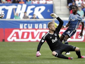 A shot by New York Red Bulls midfielder Daniel Royer, not pictured, gets by Vancouver Whitecaps goalkeeper David Ousted for a goal during the first half of an MLS soccer match, Saturday, Oct. 7, 2017, in Harrison, N.J. (AP Photo/Julio Cortez)