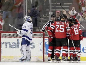 New Jersey Devils players, right, celebrate a goal by Drew Stafford (18) as Tampa Bay Lightning goalie Peter Budaj, of Slovakia, (31) composes himself during the first period of an NHL hockey game, Tuesday, Oct. 17, 2017, in Newark, N.J. (AP Photo/Julio Cortez)
