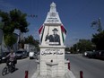 A Palestinian rides a bicycle past a monument commemorating the late Saddam Hussein in the West Bank city of Qalqiliya. Arabic reads "God is great, long live the nation, Palestine and Iraq, the Lord of the era's martyrs Saddam Hussein."