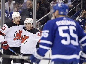 New Jersey Devils left wing Miles Wood (44) celebrates his goal with right wing Jimmy Hayes (10) as Toronto Maple Leafs defenceman Andreas Borgman (55) looks on during first period NHL hockey action in Toronto on Wednesday, October 11, 2017. THE CANADIAN PRESS/Nathan Denette