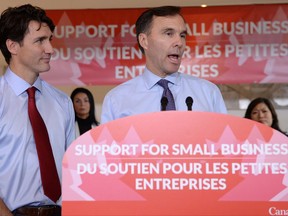 Finance Minister Bill Morneau speaks to members of the media as Prime Minister Justin Trudeau looks on at a press conference on tax reforms in Stouffville, Ont., on Monday, October 16, 2017. THE CANADIAN PRESS/Nathan Denette