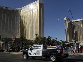 The funeral procession for Las Vegas police officer Charleston Hartfield passes the Mandalay Bay hotel on the Las Vegas Strip Friday, Oct. 20, 2017, in Las Vegas.  The off-duty police officer was one of 58 people killed when a gunman fired from the hotel into a crowded outdoor concert on Oct. 1. (AP Photo/Isaac Brekken)