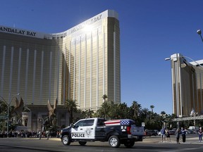 The funeral procession for Las Vegas police officer Charleston Hartfield passes the Mandalay Bay hotel on the Las Vegas Strip,  Friday, Oct. 20, 2017, in Las Vegas.  The off-duty police officer was one of 58 people killed when a gunman fired from the hotel into a crowded outdoor concert on Oct. 1. (AP Photo/Isaac Brekken)