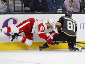 Detroit Red Wings defenseman Xavier Ouellet, left, falls against Vegas Golden Knights center Jonathan Marchessault during the first period of an NHL hockey game Friday, Oct. 13, 2017, in Las Vegas. (AP Photo/John Locher)