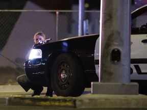A police officer takes cover behind a police vehicle during a shooting near the Mandalay Bay resort and casino on the Las Vegas Strip, Sunday, Oct. 1, 2017, in Las Vegas