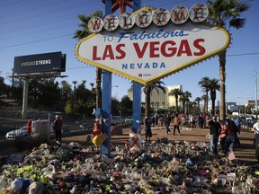 Flowers, candles and other items surround the famous Las Vegas sign at a makeshift memorial for victims of a mass shooting Monday, Oct. 9, 2017, in Las Vegas. Stephen Paddock opened fire on an outdoor country music concert killing dozens and injuring hundreds. (AP Photo/John Locher)