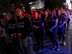 In this Sunday, Oct. 15, 2017, photo, thousands of people mark two weeks since the mass shooting at a Las Vegas country music festival by walking the Strip in Las Vegas. (Joel Angel Juarez/Las Vegas Review-Journal via AP)