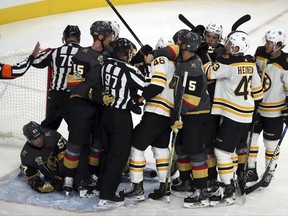 Vegas Golden Knights and Boston Bruins players come together after a minor scuffle during the third period of an NHL hockey game at T-Mobile Arena Sunday, Oct. 15, 2017, in Las Vegas. The Knights defeated the Bruins 3-1. (AP Photo/L.E. Baskow)