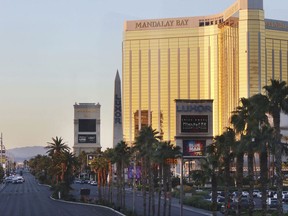 Police block a road on the Las Vegas Strip near the Mandalay Bay hotel and casino shortly after sunrise Monday, Oct. 2, 2017, in Las Vegas. A deadly shooting occurred late Sunday at a music festival on the Las Vegas Strip. (AP Photo/Ronda Churchill)