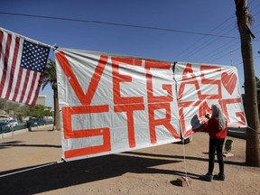 Las Vegas resident Nancy Cooley signs a Vegas Strong banner honoring the victims of a mass shooting on Thursday, Oct. 5, 2017, in Las Vegas. A gunman opened fire on an outdoor music concert on Sunday killing dozens and injuring hundreds. (AP Photo/Gregory Bull)