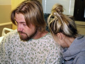 Amanda Homulos, right, hugs her boyfriend Braden Matejka at the Sunrise Hospital in Las Vegas, Wednesday, Oct. 4, 2017. The couple from Canada had traveled to Las Vegas to celebrate Matejka's 30th birthday. Matejka was shot in the back of the head by a gunman who opened fire on a music concert the couple were attending on Sunday. (AP Photo/Robert Ray)