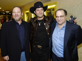 FILE - In this March 28, 2005 file photo, "Sin City" co-director Robert Rodriguez, center, poses with Miramax co-founders Harvey, left, and Bob Weinstein at the Los Angeles premiere.  Bob Weinstein,  in an interview published Saturday, Oct. 14, 2017,  by The Hollywood Reporter, he said that he and Harvey have barely spoken in five years, explaining they ran separate divisions of their company from opposite coasts. Bob said he knew Harvey was unfaithful to his wife, but had no idea of the alleged acts of sexual harassment and assault. He says he feels "sick for the victims." (AP Photo/Chris Pizzello)