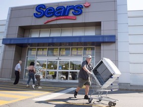 FILE - In this July 21, 2017 file photo, customers enter and leave the Sears store in St. Eustache, Quebec. Sears Canada has received court approval to liquidate all its remaining stores, putting 12,000 employees out of a job. Ontario Superior Court heard Friday, Oct. 13, that despite weeks of discussion, no viable buyer has been found. Justice Glenn Hainey approved Sears Canada's motion to liquidate its remaining 130 stores, and said he was satisfied there was no viable alternative. (Ryan Remiorz/The Canadian Press via AP, File)