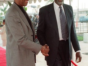 FILE - In this Oct. 16, 1999, file photo, former basketball players Connie Hawkins, left, and Bill Russell greet each other upon arrival at the the memorial service for basketball great Wilt Chamberlain, in Los Angeles. Basketball great Connie Hawkins has died at 75. The Hall of Famer's death was announced in a statement Saturday, Oct. 7, 2017,  by the Phoenix Suns, the team with which he spent his most productive NBA seasons. The Suns told The Associated Press they confirmed the death with his family. The 6-foot-8 Hawkins was a dazzling playground legend in New York City who rose to basketball's heights. The Suns lauded his "unique combination of size, grace and athleticism." (AP Photo/ Reed Saxon, Pool, File)