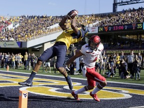 FILE - In this Oct. 14, 2017, file photo, West Virginia wide receiver Ka'Raun White (2) catches a touchdown pass in front of Texas Tech defensive back Desmon Smith (4) during the second half of an NCAA college football game in Morgantown, W.Va. (AP Photo/Raymond Thompson, File)