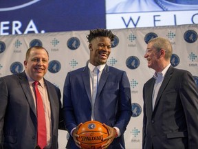 FILE - In this June 29, 2017, file photo, Minnesota Timberwolves new point guard Jimmy Butler, center, is joined by Timberwolves head coach Tom Thibodeau, left, and General Manager Scott Layden during a press conference at Mall of America in Bloomington, Minn. After a disappointing first season in Minnesota, Tom Thibodeau went to some old friends from Chicago for help. Jimmy Butler, Taj Gibson and Aaron Brooks come aboard to help the young Timberwolves get on the same page with their demanding coach. (AP Photo/Andy Clayton-King, File)
