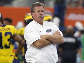 FILE - This is a Sept. 2, 2017, file photo showing Florida head coach Jim McElwain watching his team warm up before an NCAA college football game against Michigan, in Arlington, Texas. McElwain says players and families have received death threats amid the team's struggles, adding "there's a lot of hate in this world and a lot of anger." McElwain declined to say Monday, Oct. 23, 2017, whether he personally received death threats.(AP Photo/Tony Gutierrez, File)