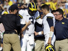 FILE - In this Saturday, Sept. 23, 2017, file photo, Michigan quarterback Wilton Speight (3) is helped off the field after getting injured in the first half of an NCAA college football game against Purdue in West Lafayette, Ind. Seventh-ranked Michigan has lost quarterback Wilton Speight for multiple weeks with an undisclosed injury. Coach Jim Harbaugh said Monday, Oct. 2, 2017, that John O'Korn will start Saturday night when the Wolverines play against Michigan State. (AP Photo/Michael Conroy, File)