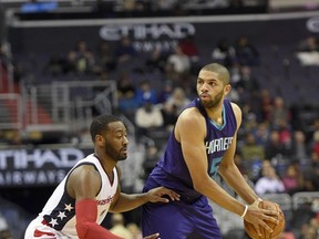 FILE - In this Wednesday, Dec. 14, 2016 file photo, Charlotte Hornets guard Nicolas Batum, of France, (5) holds the ball against Washington Wizards guard John Wall (2) during the first half of an NBA basketball game in Washington. Charlotte Hornets guard Nic Batum says some basketball fans from France are happy that he has a torn ligament in his left elbow and will be out a minimum of six to eight weeks, Friday, Oct. 6, 2017. (AP Photo/Nick Wass, File)