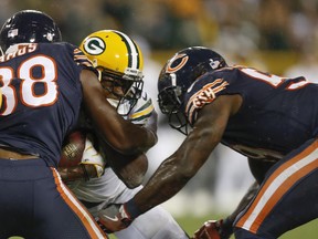 FILE - In this Thursday, Sept. 28, 2017, file photo, Green Bay Packers' Davante Adams is hit by Chicago Bears' Adrian Amos and Danny Trevathan during the second half of an NFL football game, in Green Bay, Wis. Adams was lucky he wasn't more seriously injured on Trevathan's illegal hit on the Green Bay receiver. And Chicago's thumping linebacker, who was flagged and suspended for two games, is fortunate he wasn't ejected. (AP Photo/Matt Ludtke, File)