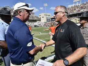 FILE - In this Oct. 1, 2016, file photo, Georgia Tech head coach Paul Johnson, left, speaks with Miami head coach Mark Richt after an NCAA college football game in Atlanta. Georgia Tech's visit to No. 11 Miami headlines the Week 7 schedule in the Atlantic Coast Conference. (AP Photo/Mike Stewart, File)