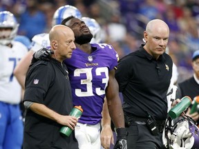 FILE - In this Sunday, Oct. 1, 2017, file photo, Minnesota Vikings running back Dalvin Cook, center, grimaces as he is helped off the field after getting injured in the second half of an NFL football game against the Detroit Lions in Minneapolis. Cook became the latest integral offensive player lost by the bad-luck-trodden Vikings. The team's fear of a torn ACL in the rookie running back's left knee was realized Monday, sealing the end of a promising rookie season. (AP Photo/Bruce Kluckhohn, File)