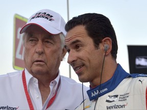 FILE - In this June 10, 2017, file photo, team owner Roger Penske, left, talks with driver Helio Castroneves, of Brazil, on pit road before an IndyCar auto race at Texas Motor Speedway in Fort Worth, Texas. Three-time Indianapolis 500 winner Helio Castroneves will move to Team Penske's sports car program next season, bringing his 20-year full-time IndyCar career to an end. Castroneves will still drive for Penske at the Indianapolis 500. (AP Photo/Randy Holt, File)