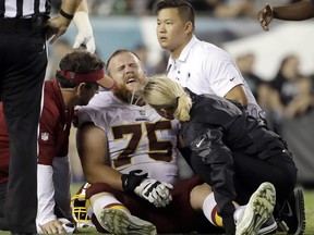 FILE - In this Monday, Oct. 23, 2017, file photo, trainers look examine Washington Redskins offensive guard Brandon Scherff (75) during the second half of an NFL football game against the Philadelphia Eagles in Philadelphia. The banged-up Redskins got some good news about Scherff's knee injury with coach Jay Gruden saying there's a chance Scherff can play Sunday against the Dallas Cowboys. Scherff sprained the MCL in his left knee and hurt his lower back, one of several Redskins injuries from a 34-24 loss at the Philadelphia Eagles on Monday night. (AP Photo/Matt Rourke, File)