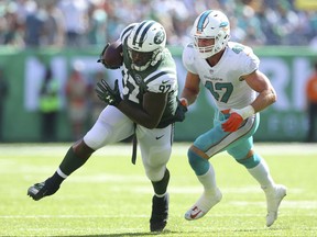 FILE - In this Sept. 24, 2017, file photo, New York Jets defensive end Lawrence Thomas (97) carries the ball against Miami Dolphins linebacker Kiko Alonso (47) during an NFL game at MetLife Stadium in East Rutherford, N.J. Lawrence Thomas is no longer a secret weapon for the Jets. The big defensive lineman has also been used through the first few weeks of the season on offense as a fullback, and even had a 15-yard reception against Miami two weeks ago.  (AP Photo/Brad Penner)