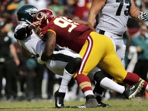 FILE - In this Sept. 10, 2017, file photo, Washington Redskins defensive end Jonathan Allen, right, knocks down Philadelphia Eagles quarterback Carson Wentz as Wentz throws a pass in the first half of an NFL football game in Landover, Md.  A foot injury likely ends the promising rookie season of the Redskins first-round pick Jonathan Allen and puts more onus on the rest of the young players on the defensive line to compensate for the loss of his production. (AP Photo/Mark Tenally, File)