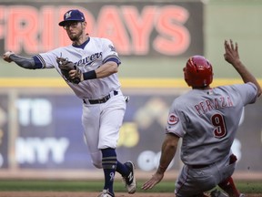 FILE - In this Thursday, Sept. 28, 2017 file photo, Milwaukee Brewers' Eric Sogard throws to first after forcing out Cincinnati Reds' Jose Paraza at second during the sixth inning of a baseball game in Milwaukee. The Milwaukee Brewers have signed infielder Eric Sogard to a one-year contract. He was eligible to become a free agent after the World Series. General manager David Stearns said Thursday, Oct. 26, 2017 that Sogard provides a "veteran presence" and is someone who can play several positions and get on base often.(AP Photo/Tom Lynn, File)