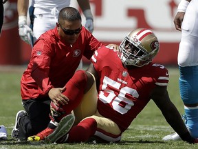 FILE - In this Sept. 10, 2017, file photo, San Francisco 49ers linebacker Reuben Foster (56) is tended to by a trainer after getting injured during the first half of an NFL football game against the Carolina Panthers in Santa Clara, Calif. The 49ers are hoping to get the talented rookie linebacker back this week after a sprained ankle sidelined him since the season opener. (AP Photo/Marcio Jose Sanchez, File)