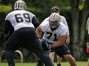 FILE - In this Tuesday, June 13, 2017 file photo, New Orleans Saints tackle Ryan Ramczyk (71) runs through drills with tackle Khalif Barnes (69) and guard Cameron Lee, right, during NFL football practice in Metairie, La. Ryan Ramczyk wasn't expecting to be thrust into the role of protecting Drew Brees' blindside. Coach Sean Payton said Thursday, Oct. 19, 2017 that Ramczyk's "toughness and a mental toughness" has enabled him to handle the movement from side to side. And he's handling his success like a seasoned pro. (AP Photo/Gerald Herbert, File)