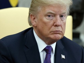 FILE - In this Oct. 19, 2017 photo, President Donald Trump listens during a meeting with Governor Ricardo Rossello of Puerto Rico in the Oval Office of the White House in Washington. Trump intends to spend at least $430,000 of his own money to help pay the legal bills of White House staff and campaign aides related to the investigations into Russian election meddling in the 2016 election. A White House official confirmed the plan, which was first reported by the website Axios.  (AP Photo/Evan Vucci, File)