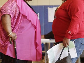 FILE - In this June 26, 2012 file photo, two women converse in New York. New government figures released Friday, Oct. 13, 2017 showed small increases that were not considered statistically significant but were seen by some as a cause for concern. The adult obesity rate rose from to about 40 percent, from just shy of 38 percent. (AP Photo/Mark Lennihan)