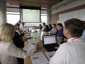 In this Aug. 17, 2017 photo, doctors, pharmacists, geneticists and others meet to discuss how to best treat cancer patients at the University of Wisconsin Carbone Cancer Center in Madison, Wis. Cancer patients increasingly are having their care guided by molecular tumor boards, a new version of the hospital panels that traditionally decided whether surgery, radiation or chemotherapy would be best. The new panels study patients' cancer genes and match treatments to mutations that seem to drive the disease. (AP Photo/Carrie Antlfinger)