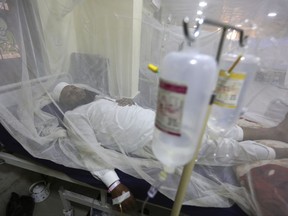 FILE - In this Thursday, Oct. 19, 2017 file photo, a patient suffering from dengue fever lies in a hospital bed in Peshawar, Pakistan. Cases of dengue fever _ a painful mosquito-borne spread disease _ have doubled every decade since 1990 with 58.4 million cases and 10,000 deaths in 2013. Dr. Howard Frumkin, a former environmental health director at the U.S. Centers for Disease Control and Prevention, said climate change, which allows mosquitoes to live in more places and stay active longer with shorter freeze seasons, is part but not all of the reason. (AP Photo/Muhammad Sajjad)