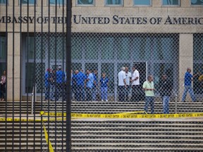 FILE - In a Friday, Sept. 29, 2017 file photo, staff stand within the United States embassy facility in Havana, Cuba. The terrifying attacks in Cuba overwhelmingly hit U.S. intelligence operatives in Havana, not ordinary diplomats, when they began within days of President Donald Trump's election, The Associated Press has learned.  To date, the Trump administration largely described the victims as U.S. Embassy personnel or "members of the diplomatic community," suggesting it was bona fide diplomats who were hit. That spies, working under diplomatic cover, comprised the majority of the early victims adds an entirely new element of mystery to what's harmed at least 21 Americans over the last year.  (AP Photo/Desmond Boylan, File)