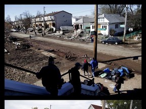 This combination of photos shows church-goers leaving Mass in the New Dorp neighborhood of Staten Island, N.Y., Sunday, Nov. 4, 2012, amid destruction caused by Superstorm Sandy and the same view five years later on Wednesday, Oct. 11, 2017. (AP Photo/Seth Wenig)