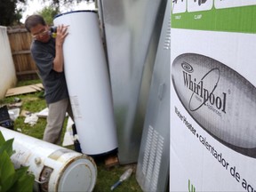 FILE - In this Sunday, March 22, 2015, file photo, a repairman installs a Whirlpool water heater at a home in Los Angeles. Sears will no longer sell Whirlpool appliances, ending a business partnership that dates make more than 100 years. (AP Photo/Richard Vogel, File)