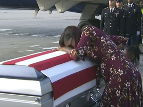 In this Tuesday, Oct. 17, 2017, frame from video, Myeshia Johnson cries over the casket in Miami of her husband, Sgt. La David Johnson, who was killed in an ambush in Niger. President Donald Trump told the widow that her husband "knew what he signed up for," according to Rep. Frederica Wilson who said she heard part of the conversation on speakerphone. (WPLG via AP)