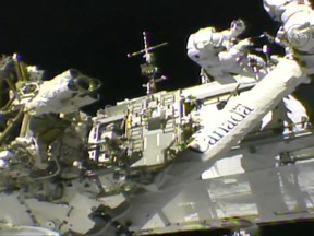 In this frame from NASA TV, Astronauts Mark Vande Hei, left, and Randy Bresnik work on the International Space Station on Thursday, Oct. 5, 2017. The astronauts went out on a spacewalk to give the International Space Station's big robot arm a new hand. (NASA TV via AP)